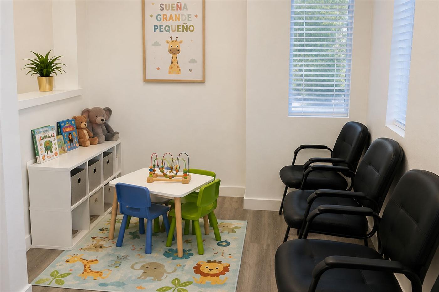 The clinic's kids' area with a play table, toys and colorful mats